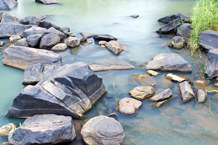 Transparent and motion blur water in river with stone