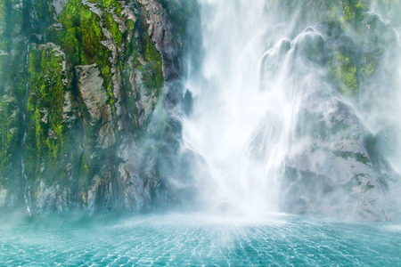 Waterfall with fluffy stream fall on the sea, Milford Sound, Southern Island, New Zealand