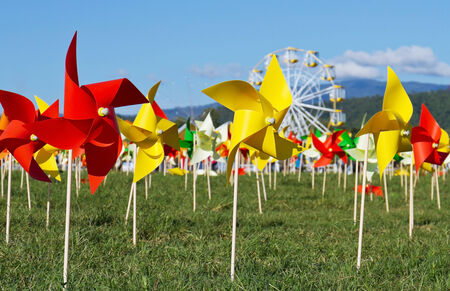 Multicolored pinwheel stands with green grassy fieldの写真素材
