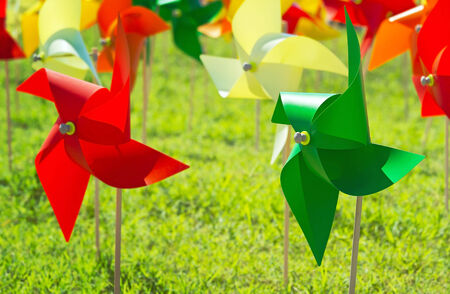 Multicolored pinwheel stands with green grassy fieldの写真素材