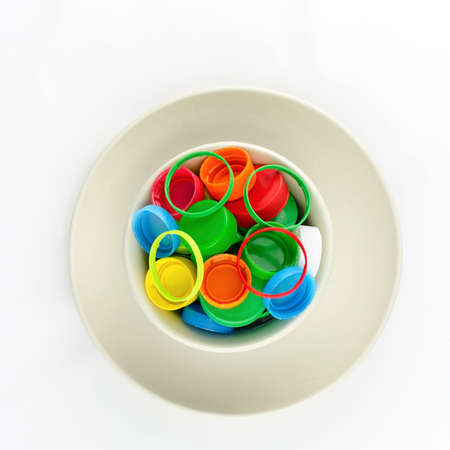 Recycle  plastic caps waste in bowl and plate isolated on white background