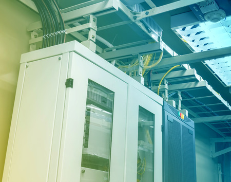 There are many cables, optic cables, and telecom equipments in the server room