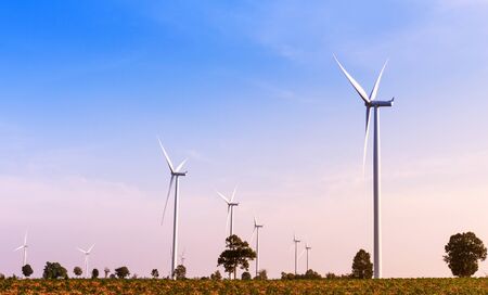 Wind turbines power generator on blue sky at farmer fieldの写真素材