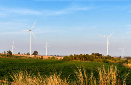 Wind turbines power generator on blue sky at farmer fieldの写真素材