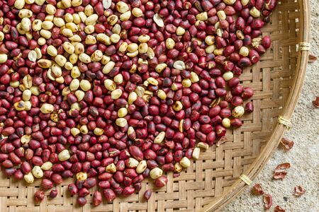 Roasted peanuts background in bamboo basketの写真素材