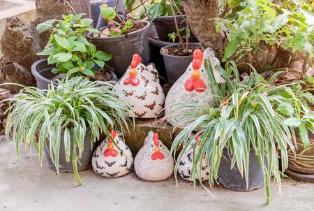 Group of cute decorative ceramic chicken setting in gardenの写真素材