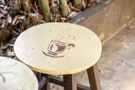 Painting a cup of coffee on wooden chair setting in garden