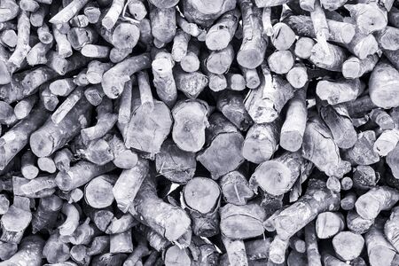 Background of dry chopped firewood logs stacked up in a pile - Black and white tone picturesの写真素材