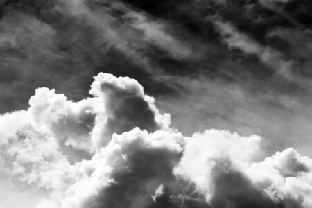 Fluffy white clouds flying on sky background in black and white tone