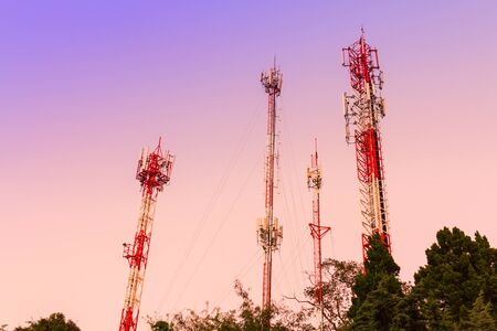 Communication towers over sunset sky in rural areas