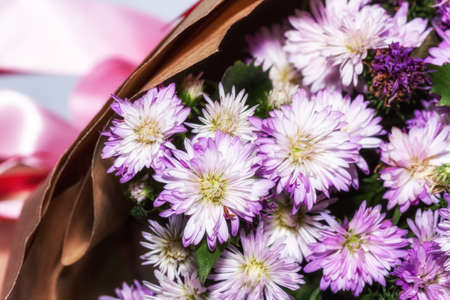 Bouquets of purple Michaelmas daisy flowers in brown color paperの写真素材