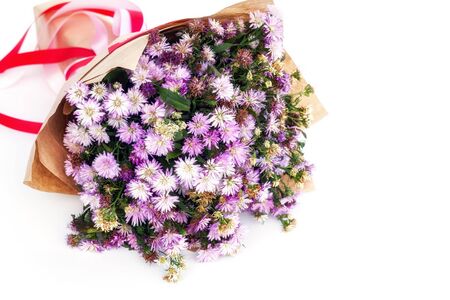 Bouquets of purple Michaelmas daisy flowers in brown color paper on white backgroundの写真素材