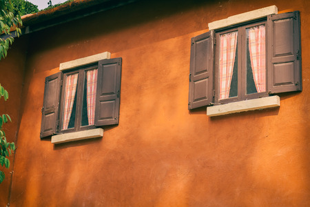 Sunshine on old wood door and orange wall on vintage style picturesの写真素材