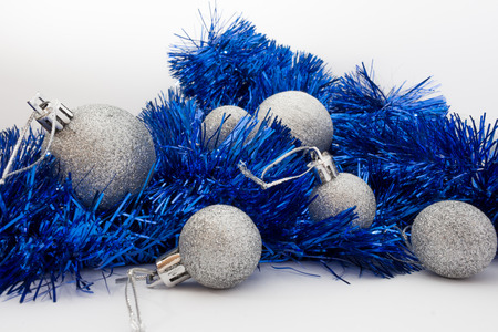 Silver shiny Christmas balls and shiny blue tape isolated on white backgroundの写真素材
