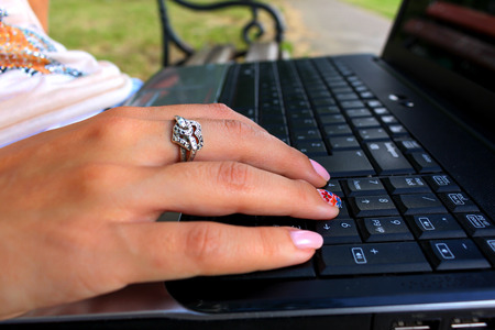 Close up of girls hand with notebook on benchの写真素材