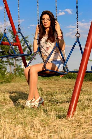 Beautiful brunette woman on swingの写真素材
