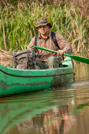 man in old canoe on the riverの写真素材