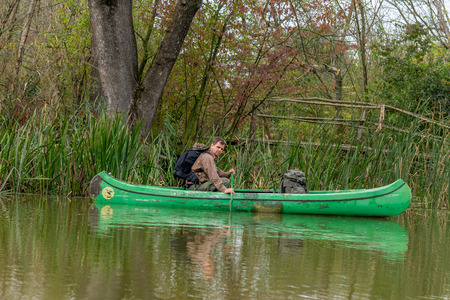 man in old canoe on the riverの写真素材