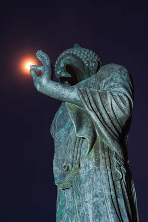 full moon and Buddha statue at Phutthamonthon (Buddhist park in Nakhon Pathom Province of Thailand)の写真素材
