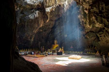 Khao Luang Cave,Phetchaburi,Thailand - natural cave with Buddha images and the large hole on the ceiling allows the rays of sunlight down to the cave floorのeditorial素材