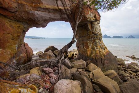 Natural hole on colorful rocks at Laem Chamuk Khwai in Khao Thong,Mueang Krabi District,Krabi province,southern Thailand.の写真素材