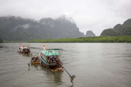 Long-tailed boats and overcast sky at Ao Thalane(Thalane Bay),Khao Thong,Krabi Province,southern Thailand.の写真素材