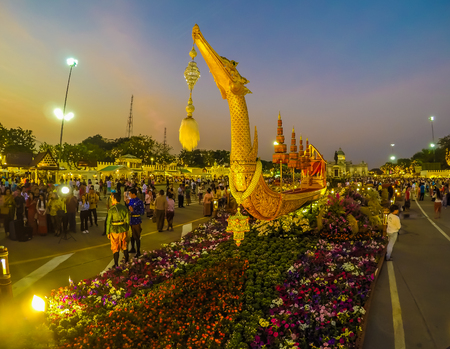 Royal winter festival,"Oon Ai Rak Klay Kwam Nao",at the Royal Plaza,Dusit Palace and Sanam Suea Pa,Bangkok,Thailand on February16,2018:Replica of Royal Barge Suphannahong with colorful flowers at the base.のeditorial素材