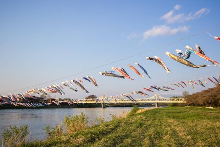 Tenshochi Park, Kitakami, Iwate, Tohoku, Japan on April 26, 2018 : Carp streamers (or koinobori) over the Kitakami River blowing in strong wind, with Sangubashi Bridge in the distance.のeditorial素材