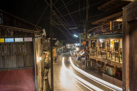 Chiangmai, northern Thailand - January 12, 2019 : Old wooden houses on both sides of small road at Mae Kampong village, a peaceful village in the middle of mountains.のeditorial素材