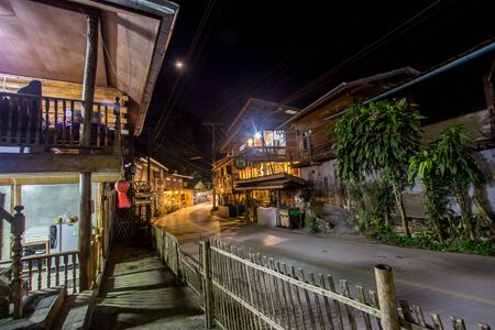 Chiangmai, northern Thailand - January 12, 2019 : Old wooden houses on both sides of small road at Mae Kampong village, a peaceful village in the middle of mountains.のeditorial素材