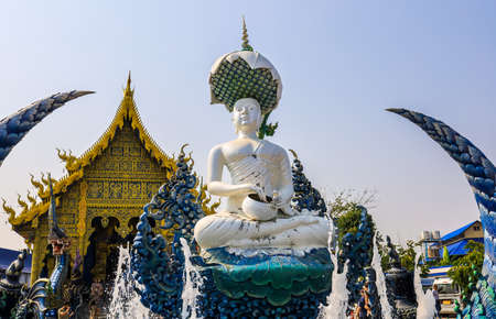 Rimkok district,Chiang Rai Province,Northern Thailand on January 19,2020:The fountain,white Buddha statue and angellic guardians in front of the main hall of Wat Rong Suea Ten or Blue Temple.(selective focus)のeditorial素材