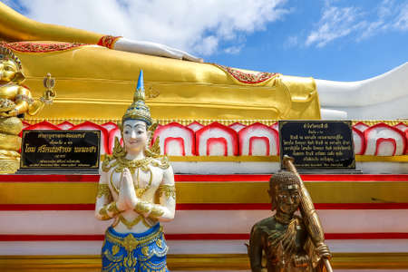 Mae Hia,Chiang Mai,Northern Thailand on Septemmber 13,2019:The figure of a deva clasping hands in token of worship in front of Reclining Buddha Statue at Wat Phra That Doi Kham.のeditorial素材