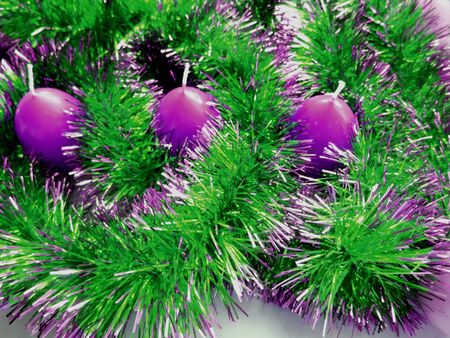 Christmas and New Year candles and green tinsel backgroundの写真素材