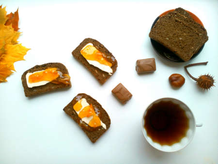 Bread with oranges jam and tea breakfast on a white backgroundの素材