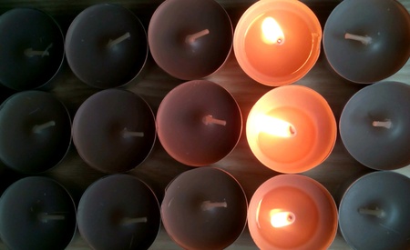 Candles and burning candles in dark on a natural wooden backgroundの素材