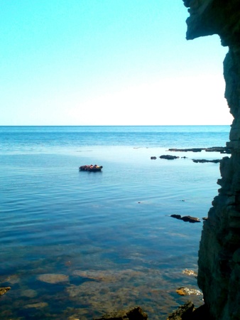 Peoples resting on the sea rock in Crimea blue background