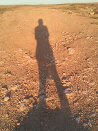 Shadows people on a steppe road backgroundの素材