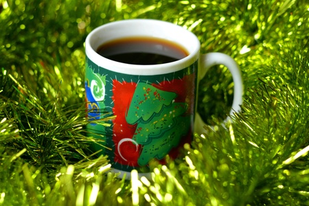 Cup of coffee christmas time green tinsel backgroundの素材
