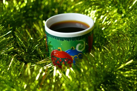 Cup of coffee christmas time green tinsel backgroundの素材