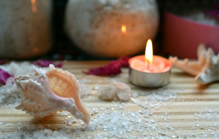 Spa sea salt bath and burning candle wood table backgroundの素材