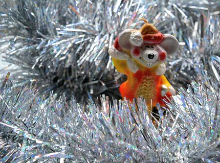 New year symbol rat decorative candle and silver tinsel on a white backgroundの素材