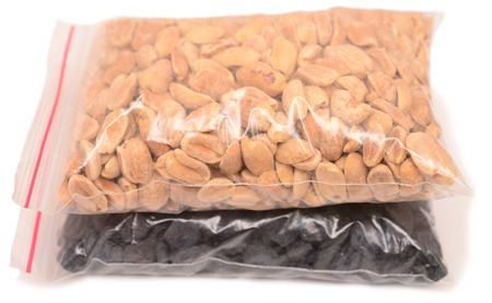 raisins and peanuts in plastic packages on a whiteの写真素材