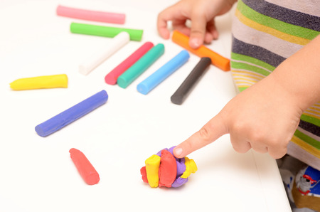 little boy playing with clay dough, education and daycare conceptの写真素材