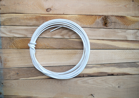 coil of electrical cable on a wooden backgroundの写真素材