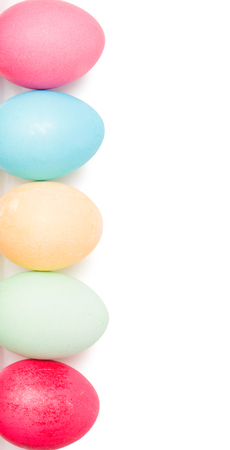 Easter eggs in a wicker basket on a white backgroundの写真素材