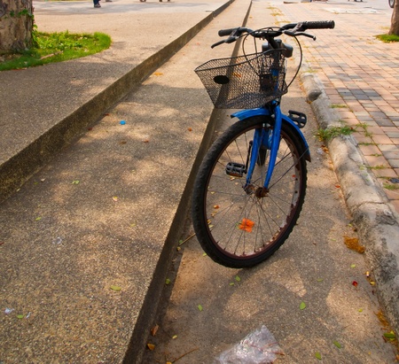 Old bicycle parked on the stone walkwayの写真素材