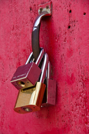 Three keys hanging on a red door の写真素材