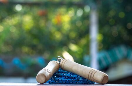 Blue jump rope handles, wooden table with bokeh background.の写真素材