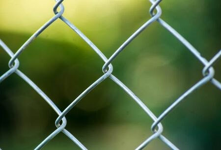 Closed up metal fence is Bokeh green