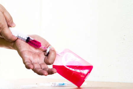 Syringe full of medicine, liquid in  bottle,red